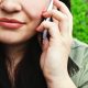 A photograph of a close up of a woman with a phone to her ear for our scam calls article