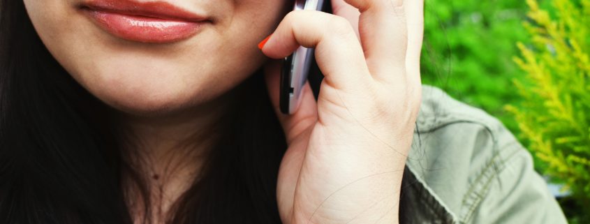 A photograph of a close up of a woman with a phone to her ear for our scam calls article